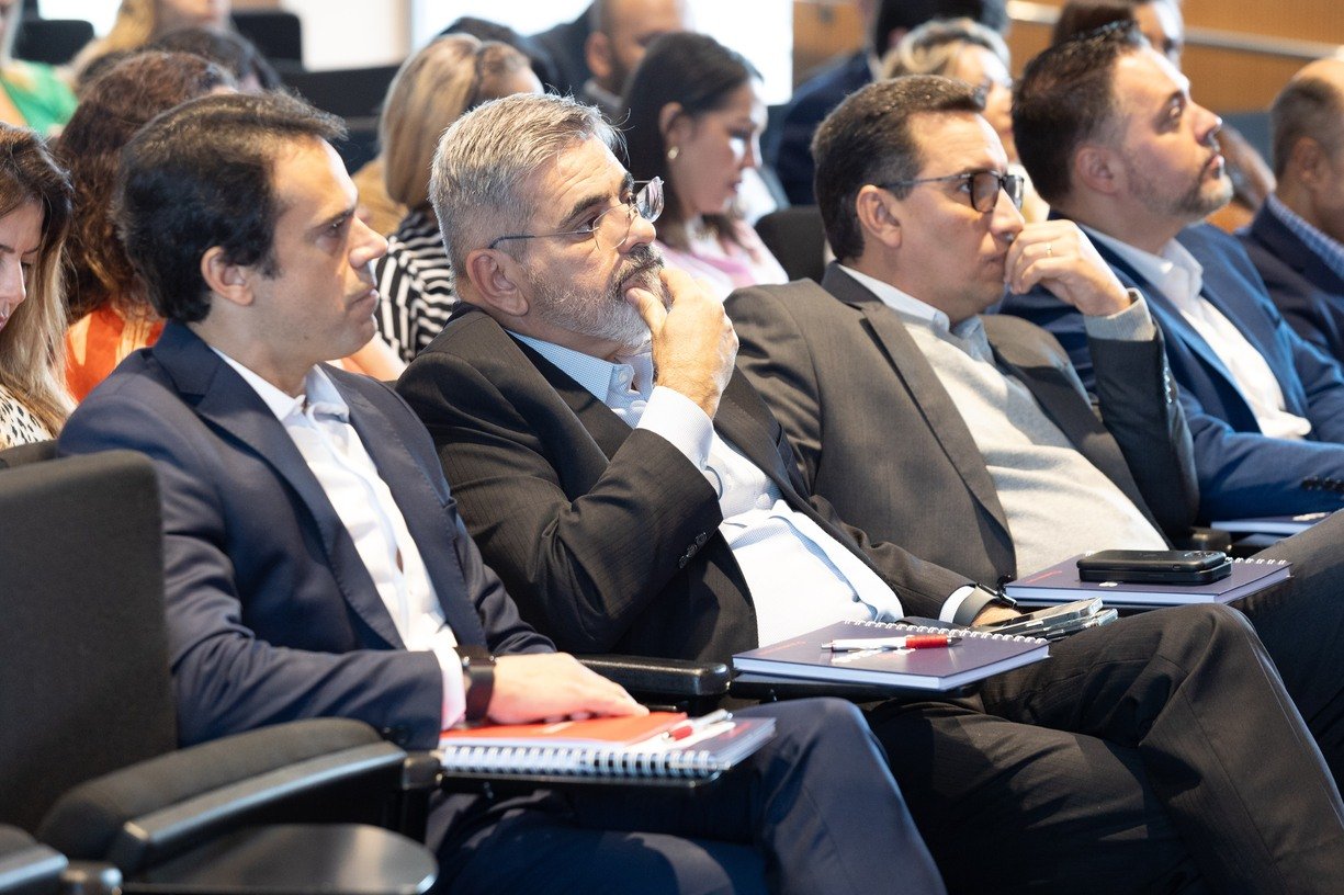 Participantes acompanham uma apresentação em evento empresarial